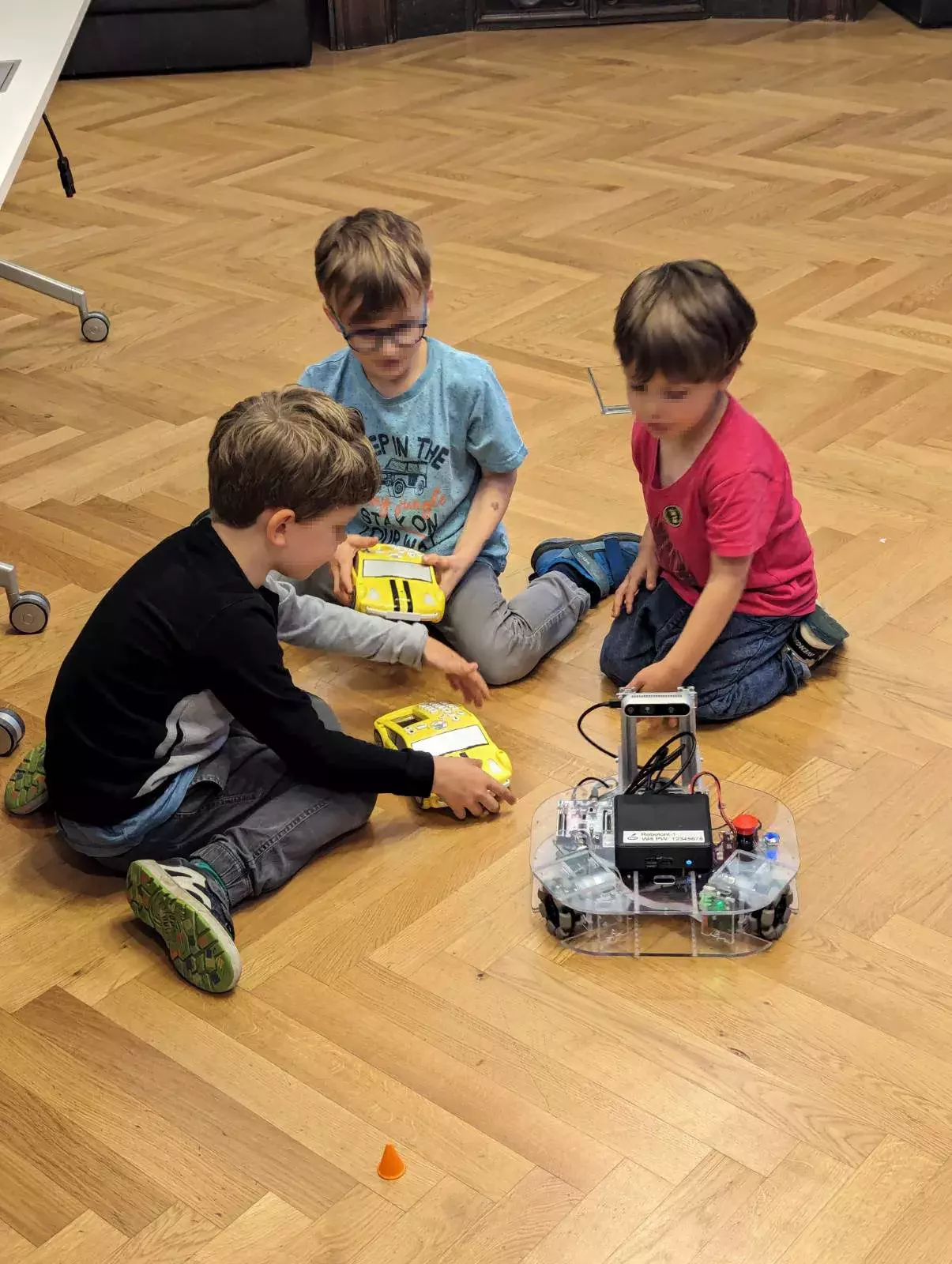 Lange Nacht der Forschung 2024 Station Robotik: 3 Kinder spielen mit Robotern