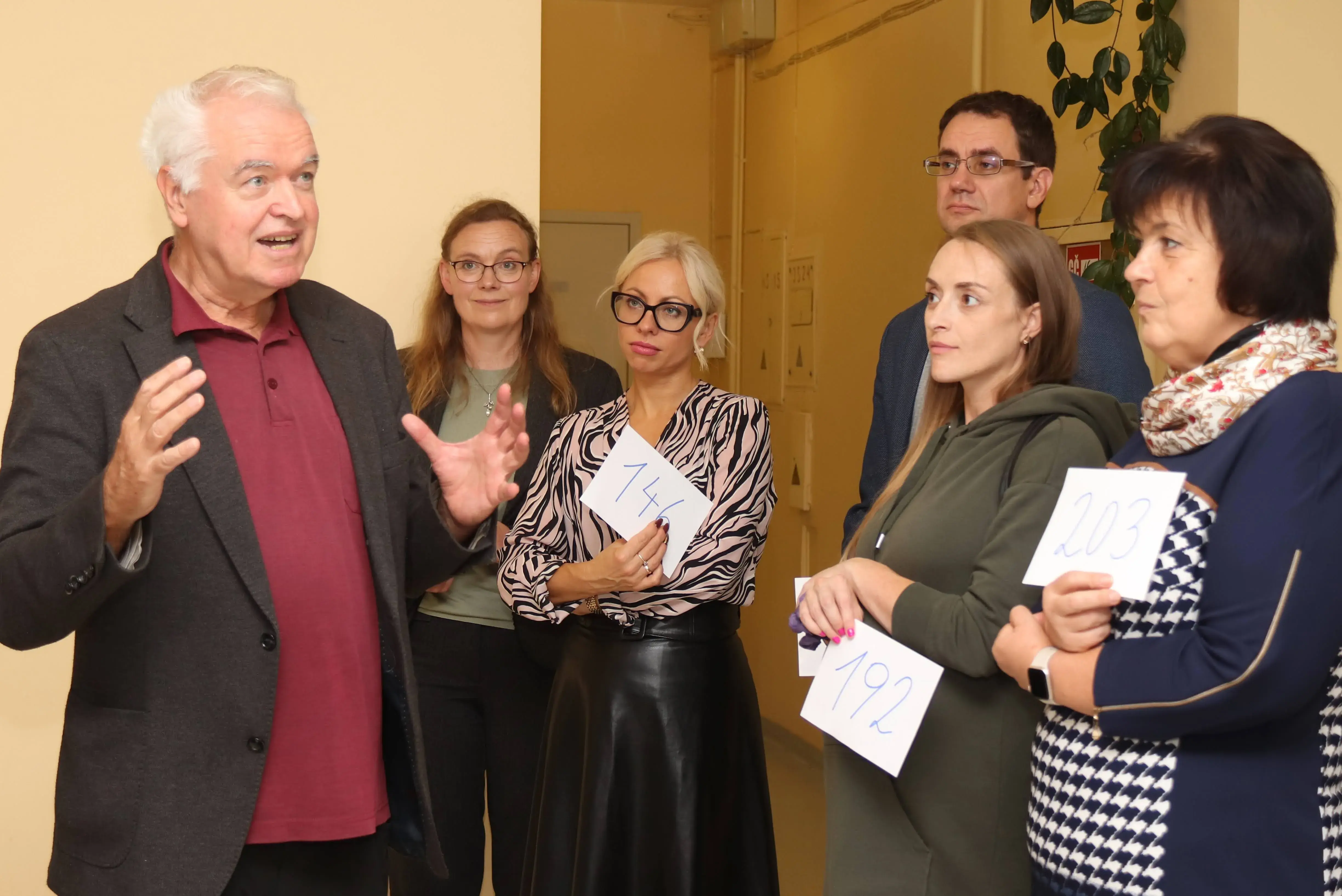 Gerald Futschek umringt von fünf anderen Personen, die ihm aufmerksam zuhören. 